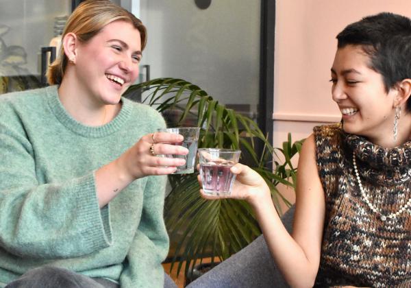 Coworkers sitting in a Melbourne office drinking water from a water cooler