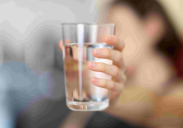 Close up of female hands holding a glass of water