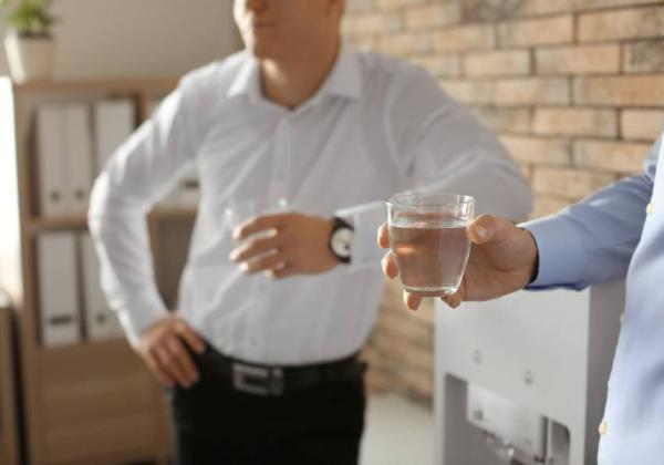 Employees drinking water near water cooler in Melbourne office