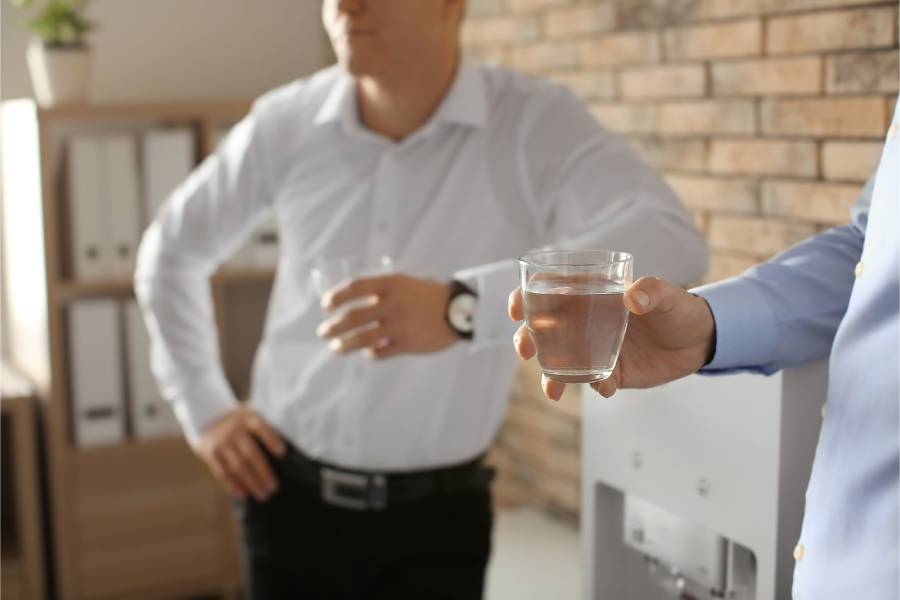 Employees drinking water near water cooler in Melbourne office