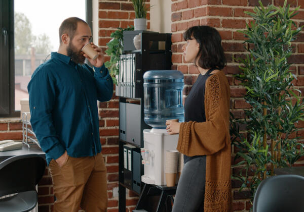 Two workers talking near a water cooler in Geelong workplace